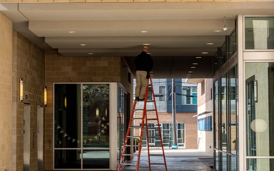 Worker replacing lights in a commerical property